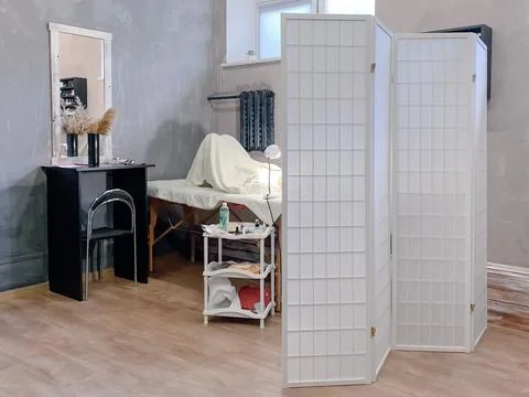 Workplace of lashmaker located behind white folding screen in modern apartmen Stock Photos