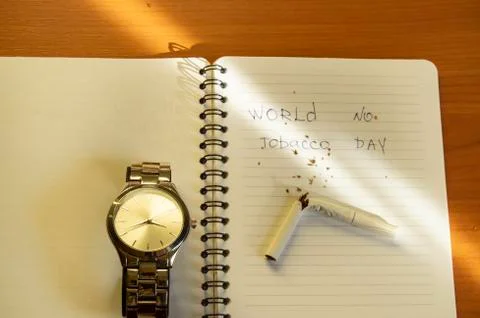 Workplace men with hours, diary, broken cigarette, and text A day without TOB Stock Photos