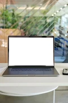 Workplace in modern office with white empty mock up screen pc laptop computer. Stock Photos
