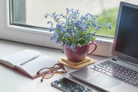 Workplace with notebook laptop Comfortable work table in home office windows and Stock Photos