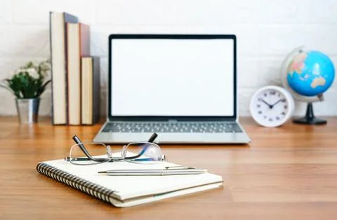 Workplace with notepad and laptop on table at home Stock Photos