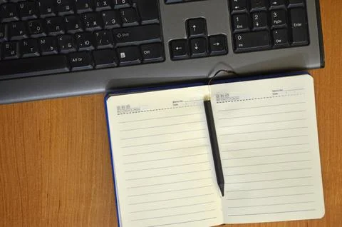 Workplace with notepad - diary, pencil and keyboard Stock Photos