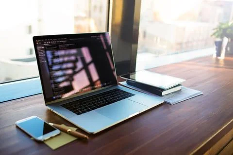 Workplace with open pc laptop computer lying on a wooden table near mobile ph Foto stock