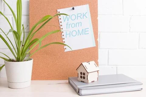 Workplace on self-isolation, cork board, flower and notebook on the backgroun Stock Photos