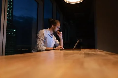 At workplace sit African employee work until late on laptop Stock Photos