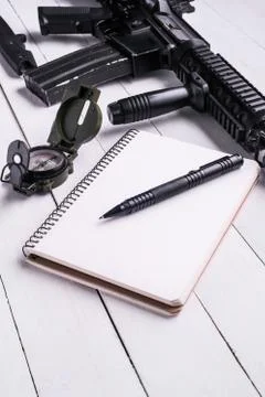 Workplace for soldier : open notebook with pen,compass and rifle Stock Photos