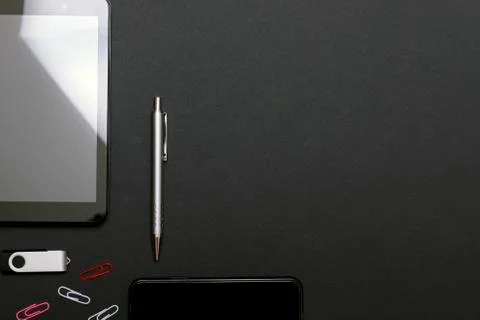 Workplace, tablet pc and smart phone on black table. Set of black accessories Stock Photos
