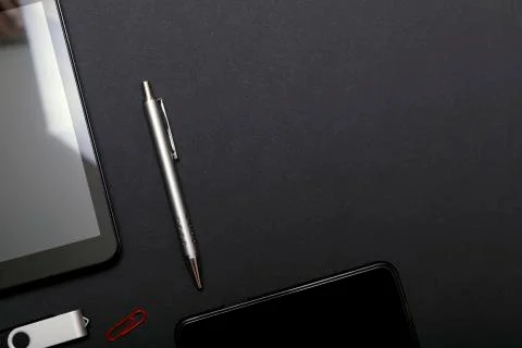 Workplace, tablet pc and smart phone on black table. Set of black accessories Stock Photos