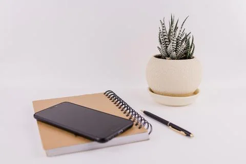 Workplace on white background with notepad smartphone flower and pen Stock Photos