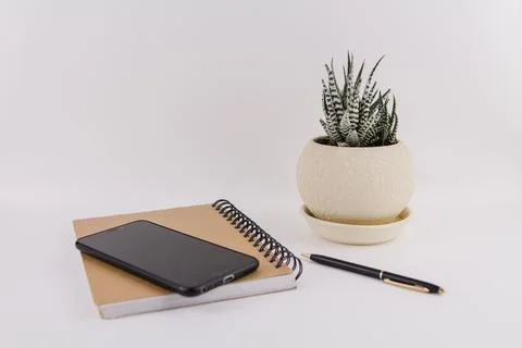 Workplace on white background with notepad smartphone flower and pen Stock Photos
