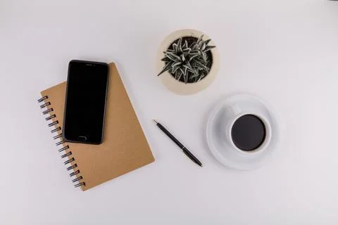 Workplace on white background with notepad smartphone flower and pen and cup  Stock Photos