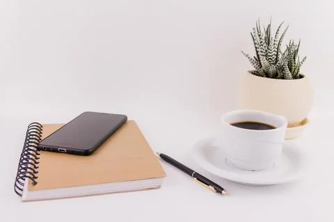 Workplace on white background with notepad smartphone flower and pen and cup  Stock Photos
