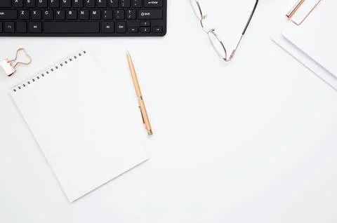 Workplace with white notebook, black keyboard, stationery, glass of water wit Foto stock