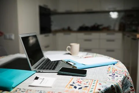 Works at the computer on the table near the kitchen Stock Photos