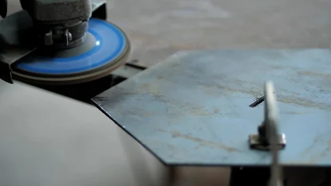 In the workshop. Close-up. The man grinds a metal part with an Angle grinder Stock Footage 128998158