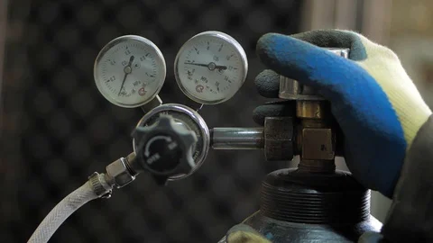 In the workshop. Close-up. The man opens an oxygen cylinder for welding Stock Footage 128998122