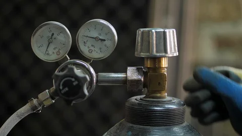 In the workshop. Close-up. The man opens an oxygen cylinder for welding Stock Footage 128998178