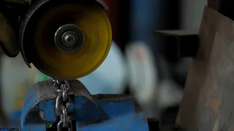 In the workshop. Close-up.The man saws the chain into parts using a circular saw Stock Footage 128998146