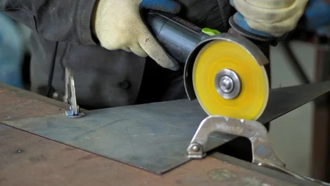 In the workshop. Close-up. The man saws the metal sheet using a circular saw Stock Footage 128998147