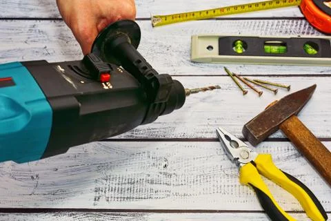 Workshop concept - hand tools and a perforator in hand Stock Photos