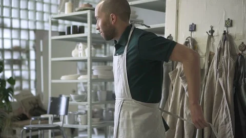 In workshop craftsman wears an apron before starting work. Stock Footage 87324503