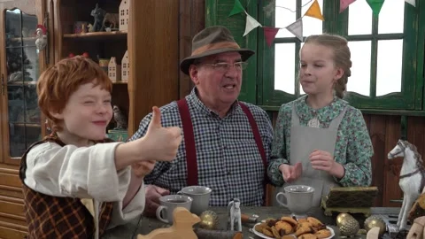 In the workshop, the Grandfather drinks tea with his grandson and granddaughter. Stock Footage 147143362