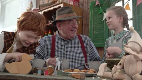 In the workshop, the Grandfather drinks tea with his grandson and granddaughter. Stock Footage 147143426