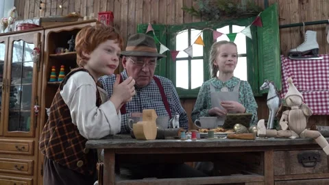 In the workshop, the Grandfather drinks tea with his grandson and granddaughter. Stock Footage 147143445