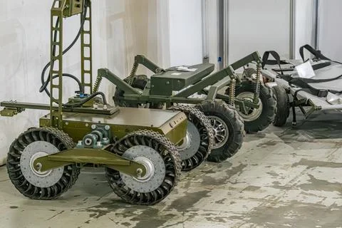 A workshop image showcases two greenish-gray military mini robots, possibly a Stock Photos