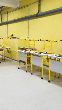 Workshop interior with work tables and tools setup in bright yellow room. Stock Photos