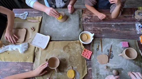 Workshop for kids. Children learning how to use clay for making dishes. Stock Footage 292828040