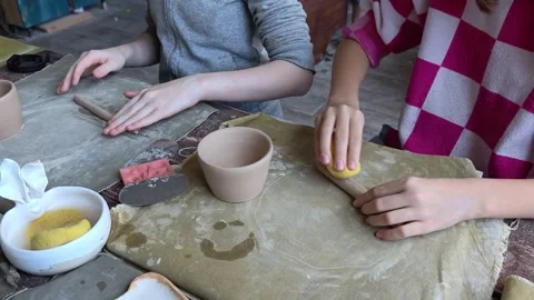 Workshop for kids. Children learning how to use clay for making dishes. Stock Footage 292928619