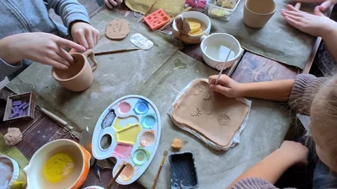 Workshop for kids. Children learning how to use clay for making dishes. Stock Footage 292930244