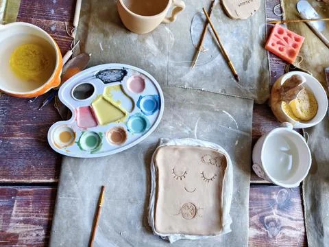 Workshop for kids. Children learning how to use clay for making dishes. Stock Photos