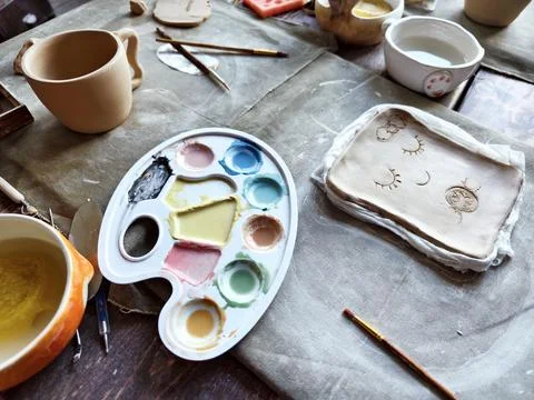 Workshop for kids. Children learning how to use clay for making dishes. Stock Photos