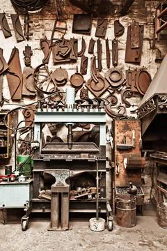 Workshop, metal tools and forge with wall background for industry, vintage Foto stock