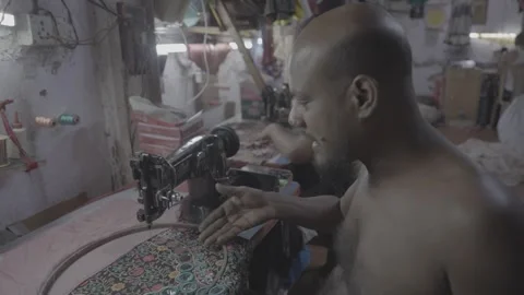 A workshop in Mumbai, India, and men sewing in humid conditions Stock Footage 345389583