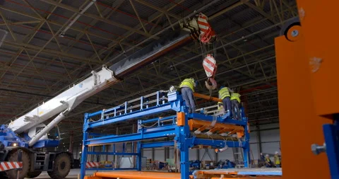 In the workshop of a plant under construction, a truck crane holds equipment  Stock Footage 161990513