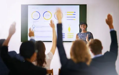 Workshop in progress. Shot of a group of people raising their hands in a class. Stock Photos