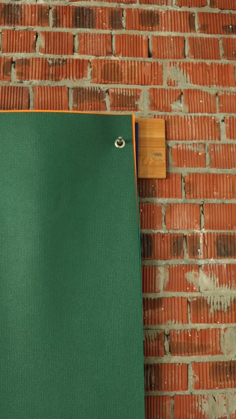 Workshop setting with colorful stack of gym mats leaning against exposed brick Stock Footage 304739539