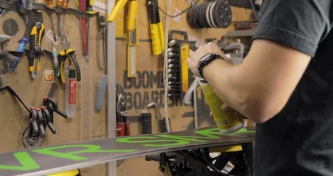 Workshop With Snowboard Repair Tools. Master Is Using Degreaser Cleaner Stock Footage 125858111