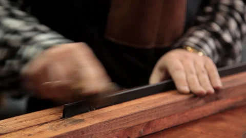 In the workshop, a specialist sharpens a leather belt. Procedure for the Stock Footage 86707609