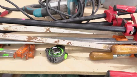 Workshop tools including clamps, tape measure and power tool rest on a work.. Stock Footage 344907487