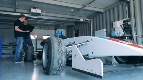 Workshop with two specialists discussing a racing cart Vidéo 163503288