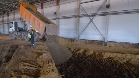 In a workshop under construction, a truck unloads the soil to level the ground Stock Footage 161955431