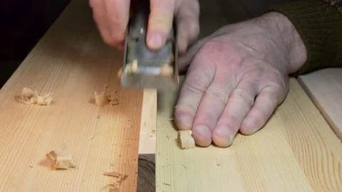 Workshop, woodworking.The master makes a chamfer on the board with a planer. Stock-Footage 151304813