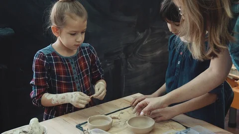 Workshop for work with clay. Mom with two little daughters are busy modeling Video stock 90259527