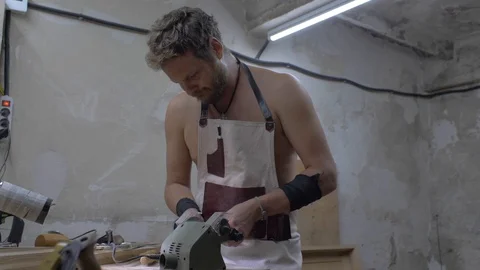 Workshop worker grinds tool on grindstone. a man sharpening a chisel before work Stock Footage 116722326
