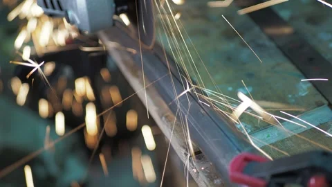 Workshop. A worker uses a angle grinder to cut a steel pipe. 스톡 동영상 311759882