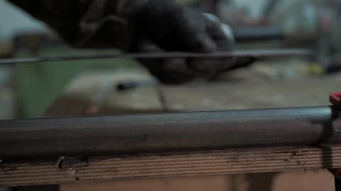 Workshop. A worker uses a steel ruler to draw a line on a pipe. Stock Footage 311759838
